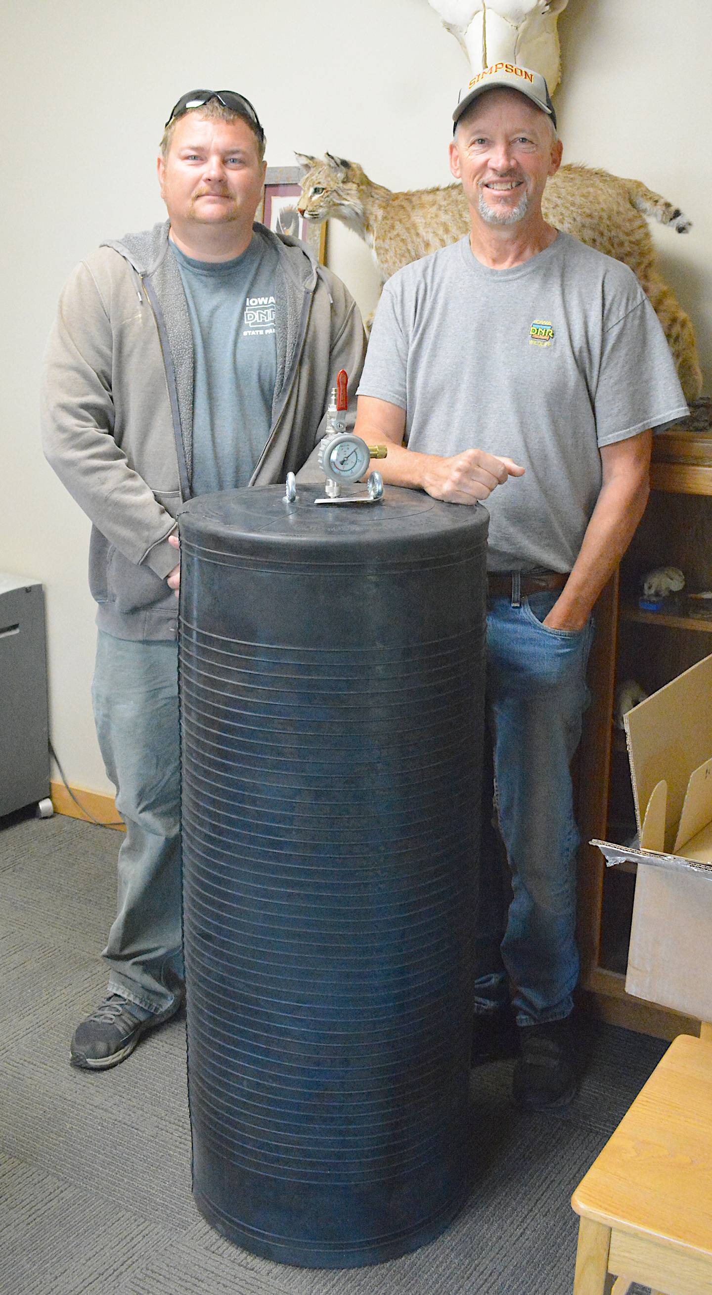 Creston Fire Assistant Chief Daniel Stull, left, and Iowa DNR Wildlife Biologist Chad Paup pose with the inflatable plug to be used for a dive operation which took place Friday.