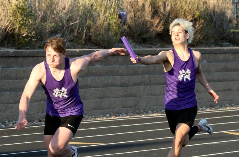 Wolverine senior Eli Harris reaches for the baton from junior Kevin Steele in a relay at the Earlham track meet Tuesday, April 15.