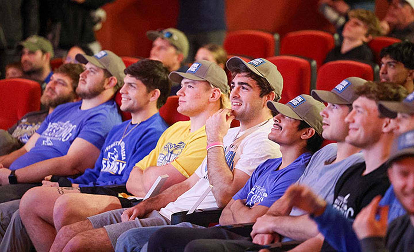 Jackson Kinsella (center, white shirt) enjoys a moment during the championship reception for the Nebraska-Kearney wrestling team Sunday. Heavyweight Crew Howard of Clarinda is seated to Kinsella's right.