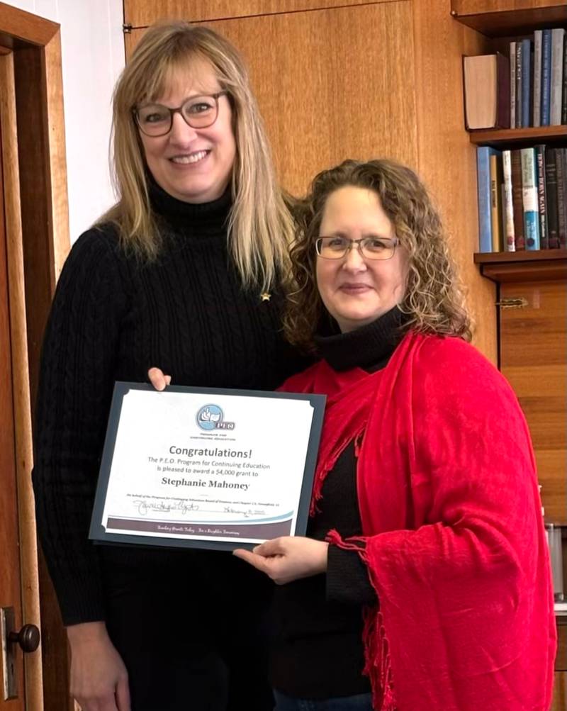 Stephanie Mahoney, right, receives an award for a scholarship that will help her finish the rest of her master's degree, from Jayne Mazurkiewicz.