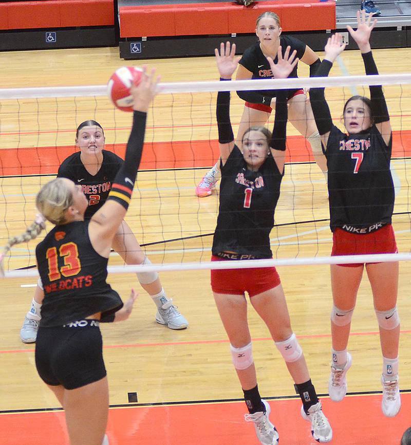 Creston's Kadley Bailey (1) and Hope Henderson (7) reach to block against Carlisle's 6-1 middle hitter Sydney Light (13) Thursday as Hollyn Rieck (2) and Jaycee Hanson cover from behind.