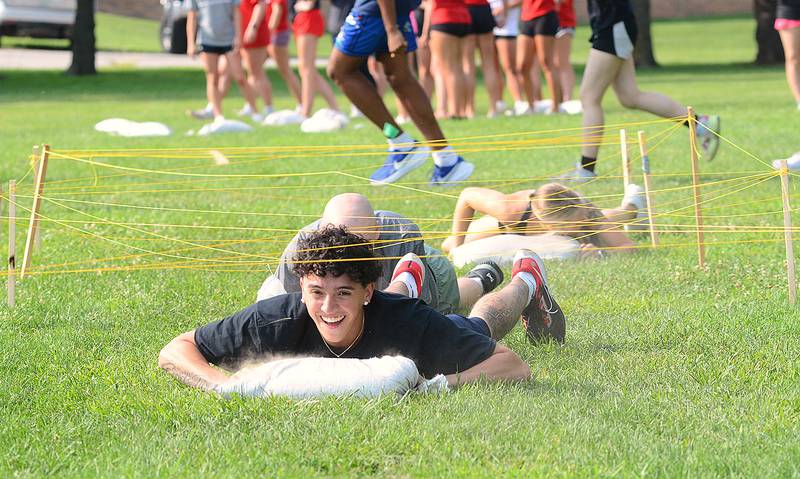 Athletes traverse through an army crawl obstacle course while moving a sand bag during one of the challenge tasks in Friday's mental training program at Southwestern Community College. There was a cognitive task at the end of the course.