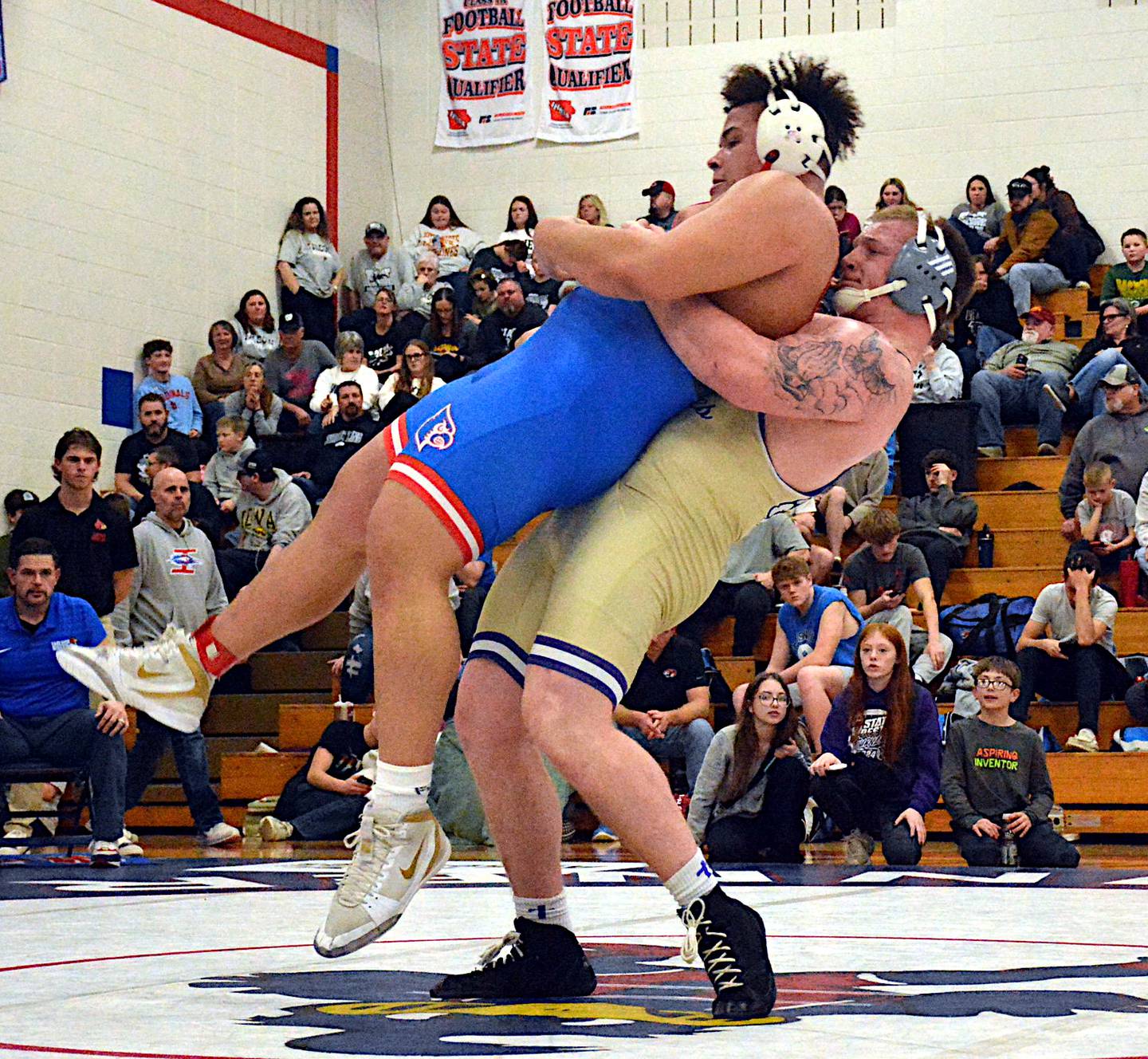 Wolverine senior Ashton Honnold sends a message, lifting Earlham's Keegan Long into the air for a mat return in their 285-pound district championship match.