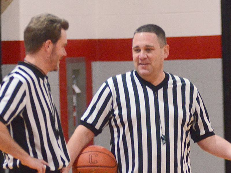 Jeff Veitz (right) speaks with fellow official Brandon Phipps during a break in the action at a middle school basketball game last season. Veitz has worked as a local official for 20 years.