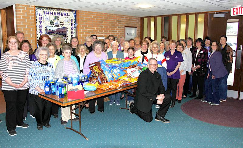 Participants in a Lutheran women's rally at Immanuel Lutheran Church in Greenfield around items gathered for mission outreach.