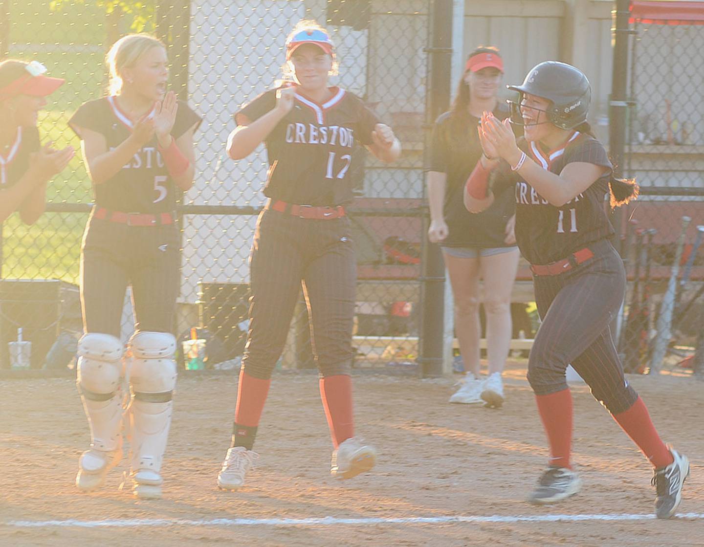 Creston senior Mila Kuhns celebrates with teammates after her three-run home run in the third inning extended Creston's lead to 14-1 over Greene County.