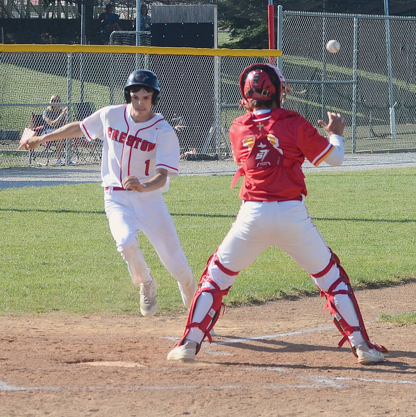Gavin Millslagle of Creston beats the throw to home plate to score on Tyler Riley's double in the first game of Monday's doubleheader against Kuemper Catholic. Millslagle had two hits in the doubleheader and made a spectacular catch in deep right field to thwart a Knight rally in the second inning.