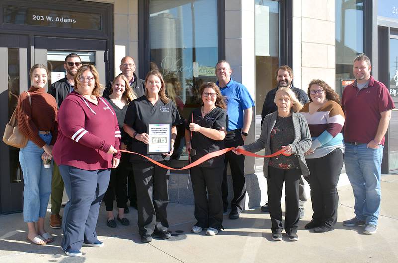 Discover Medical Thermography held their ribbon cutting Thursday. Angie Utterback holds the Creston Chamber of Commerce's first dollar of profit while Alesha Hadley cuts the ribbon.