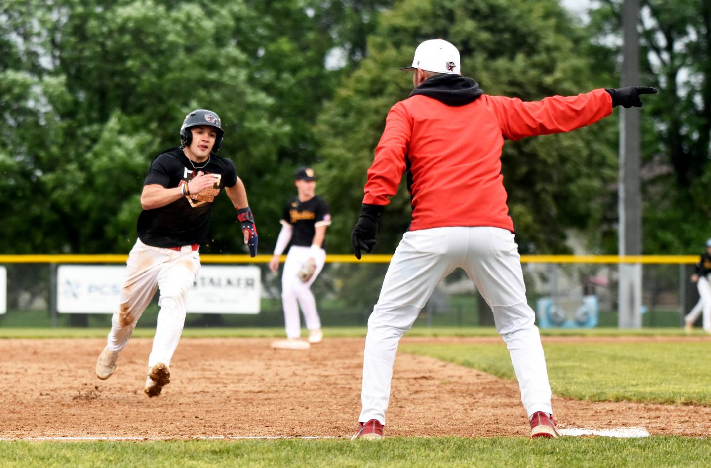 Coach Brandon Phipps points pinch runner Seth Gordon to home.