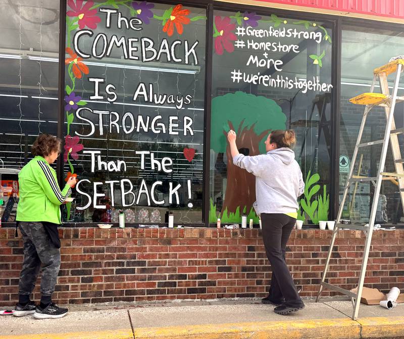 Pam Kirkland and Gina Shelley paint an encouraging message saying "the comeback is always stronger than the setback" on the front of Greenfield Home Store and More in Greenfield. Bre Fitzgerald also helped with the art.