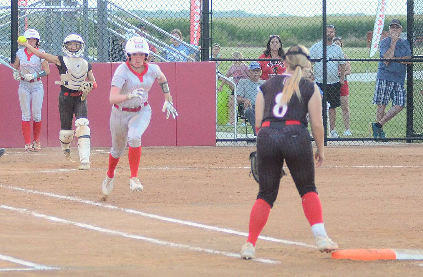 Creston catcher Ava Adamson throws to first baseman Jaycee Hanson after a dropped third strike against Dallas Center-Grimes. Adamson had two hits in the 8-2 loss.