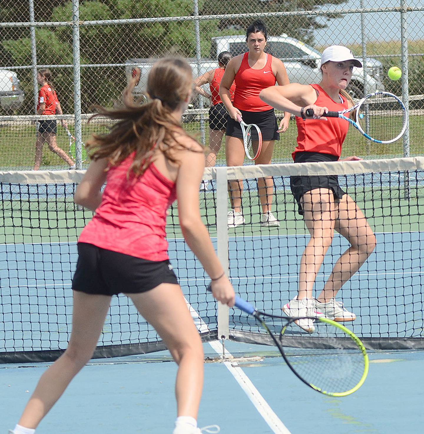 Hollynn Rieck punches a volley at the net in front of teammate Kennedy Strider during their doubles win Thursday against Chariton. Rieck and Strider went 4-0 in singles and doubles against Chariton and Audubon on Friday.