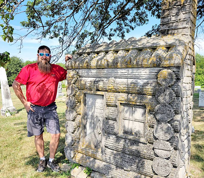 Rob Hull alongside one of the stranger monuments he helped clean in Union County, a miniature log cabin made of stone. Although you can't open it, the names are engraved on the door.