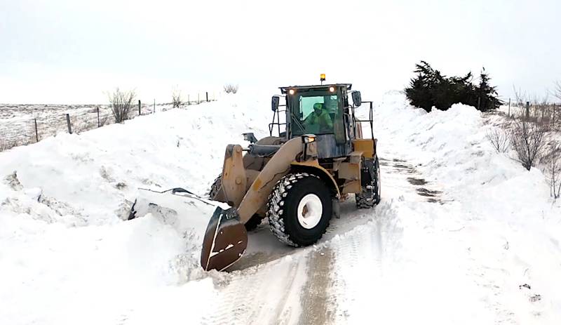 An Adair County Secondary Roads worker uses a large wheel loader to move snow to the sides of a rural road during January snow storms that dumped 16 inches of snow in a four-day span on Greenfield and surrounding areas.