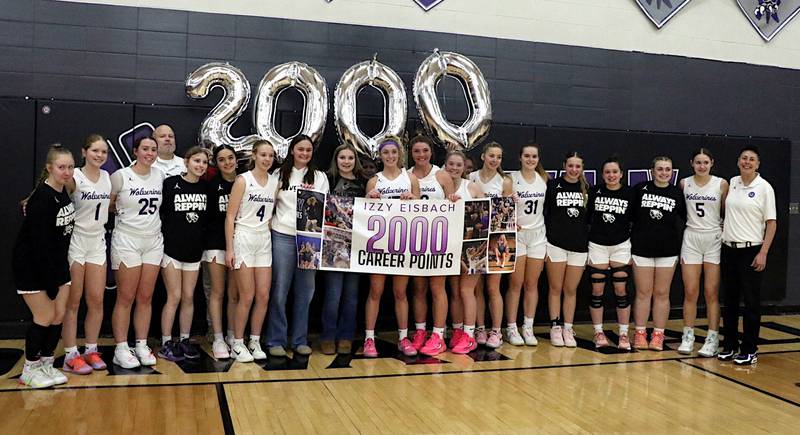 Nodaway Valley senior Izzy Eisbach celebrates with her teammates and coaches after reaching 2,000 career points last Tuesday against Lenox.
