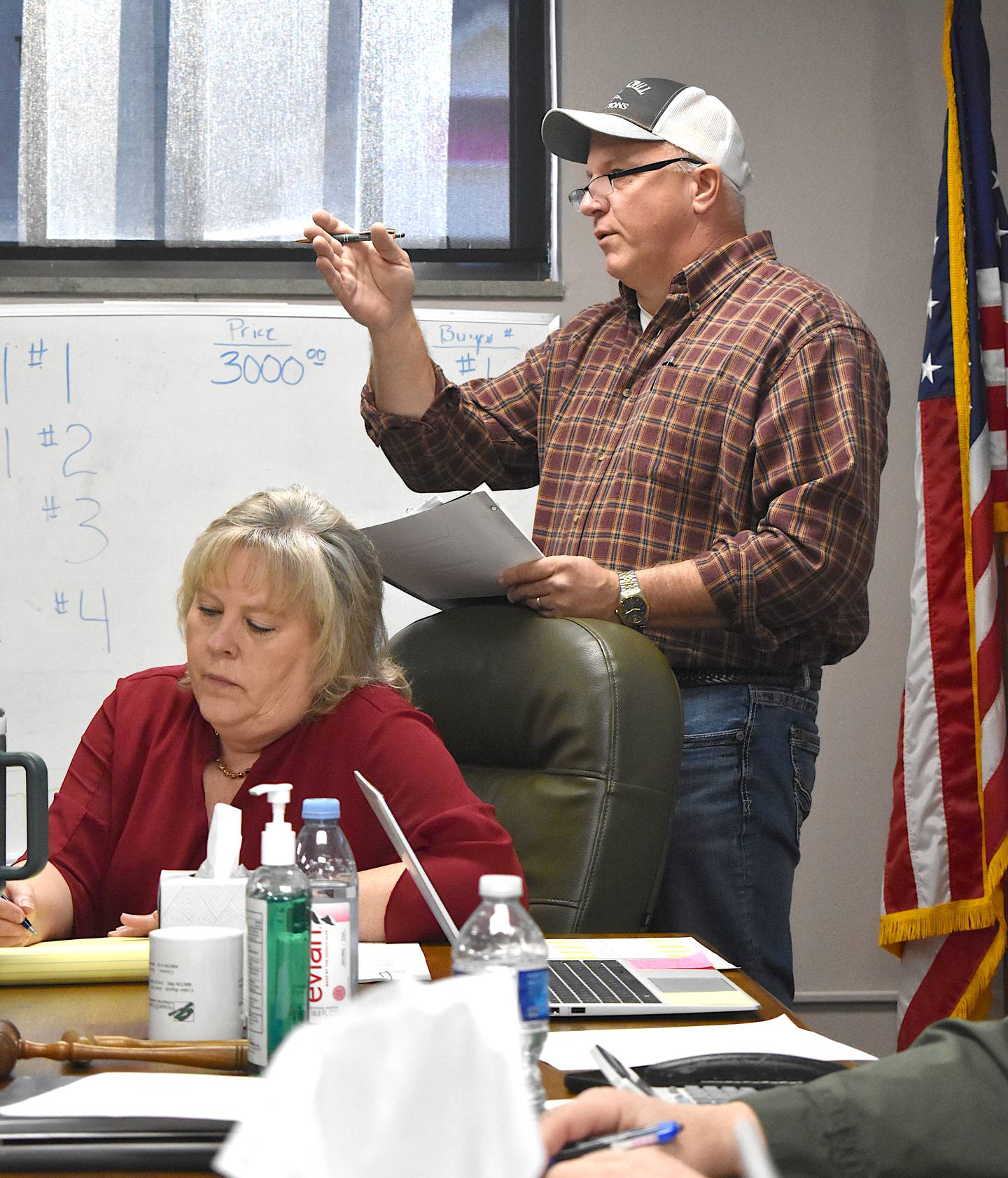 Auctioneer Jim Crill chants while auctioning parcels of land during a county meeting.
