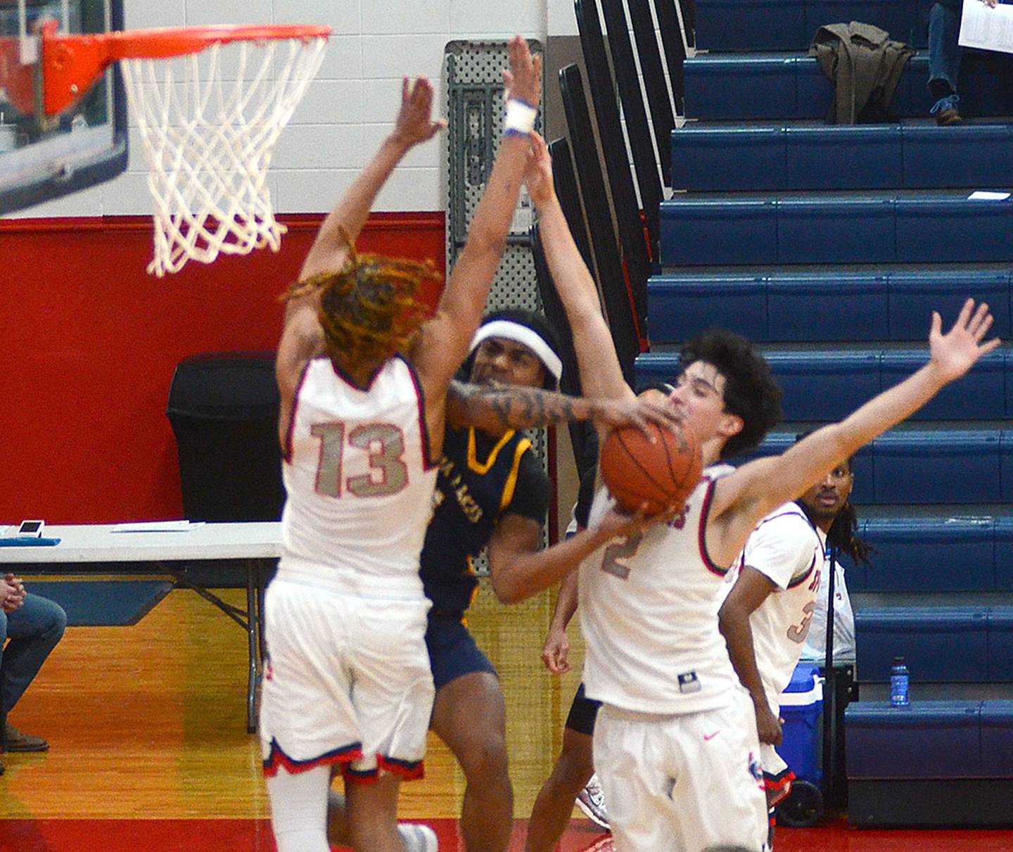 Southwestern's Justine De La Cruz (13) and Alec Belter defend a drive by Jermaine Freeman of Iowa Lakes.