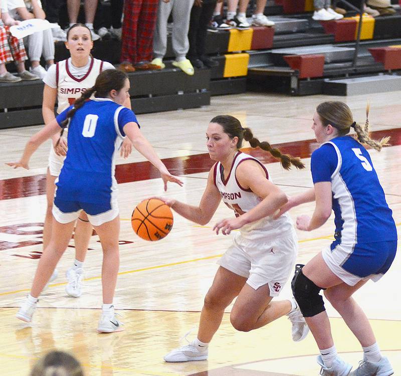 Simpson junior Doryn Paup of Creston drives to the basket as teammate Maddax DeVault of Greenfield waits for a pass at the 3-point line. Tuesday's game was their final appearance together for the Storm.