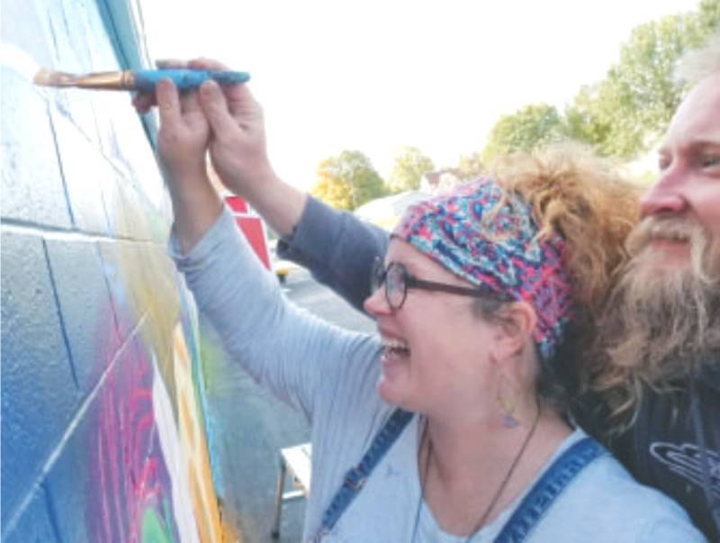 Blake Fry-Schnormeier of Create Creston assists his wife, Creston Community High School art teacher Bailey Fry-Schnormeier, with a mural on the side of Ramsey's Market in Lenox. The Fry-Schnormeiers were selected as Creston's 2020 Volunteers of the Year after coordinating a summer mural program this year.