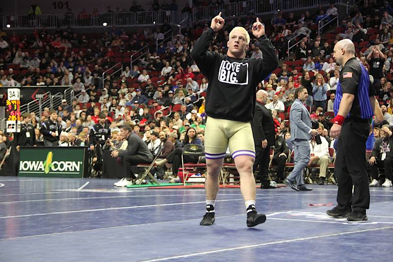 Nodaway Valley senior Ashton Honnold points to the sky, donning a shirt that says, "Love Big" after winning his third state title.