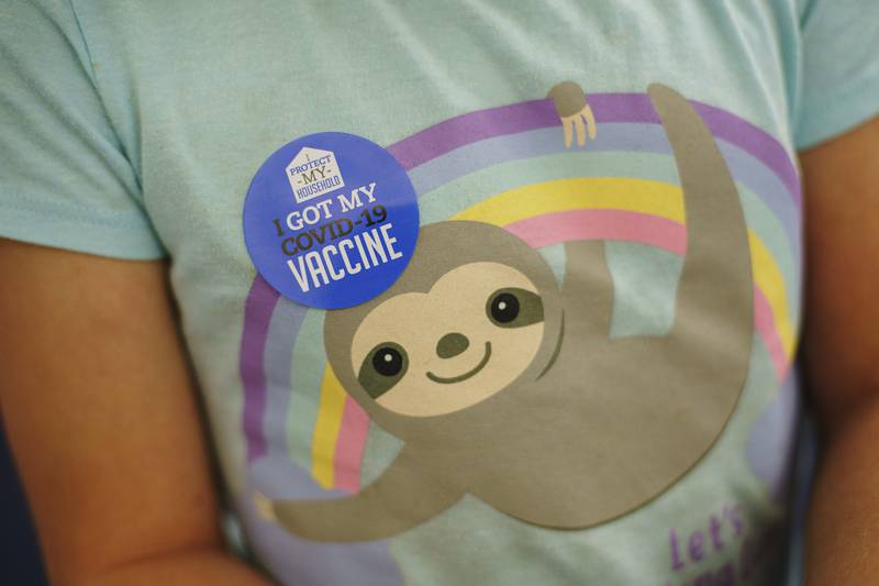 Julia Breguet, 8, wears a sticker on her shirt after receiving the Pfizer COVID-19 vaccine for children ages 5-11 at a state-run site in Cranston, R.I., Thursday, Nov. 4, 2021.