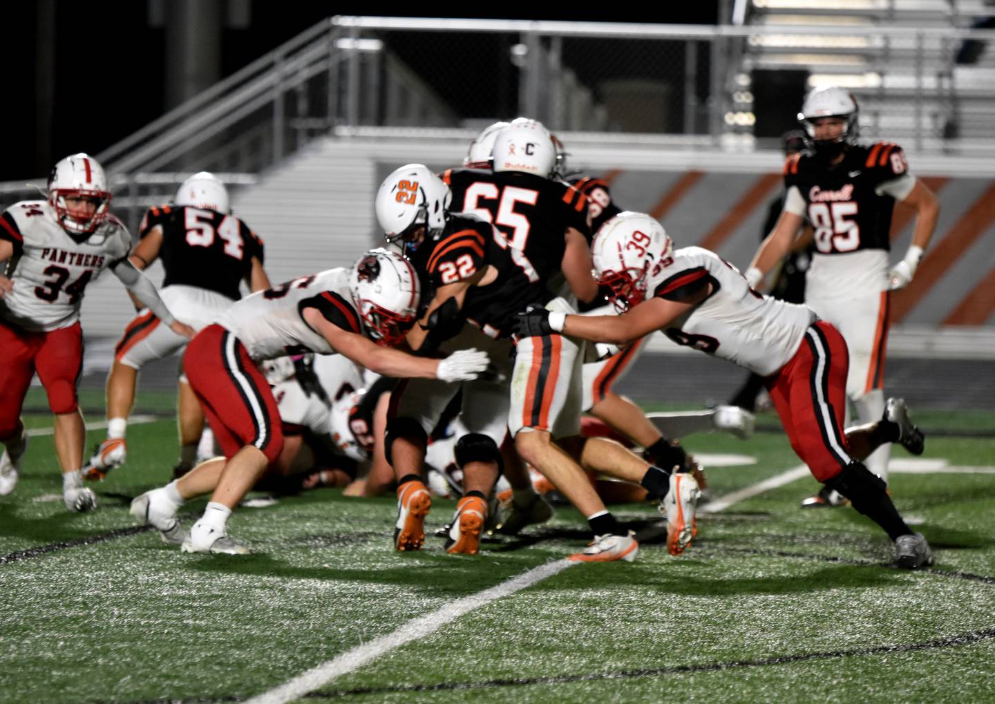 Carroll running back Adam Malik (No. 22) is stopped by Creston’s Jackson Pettegrew (left) and Blake Hayes (right).