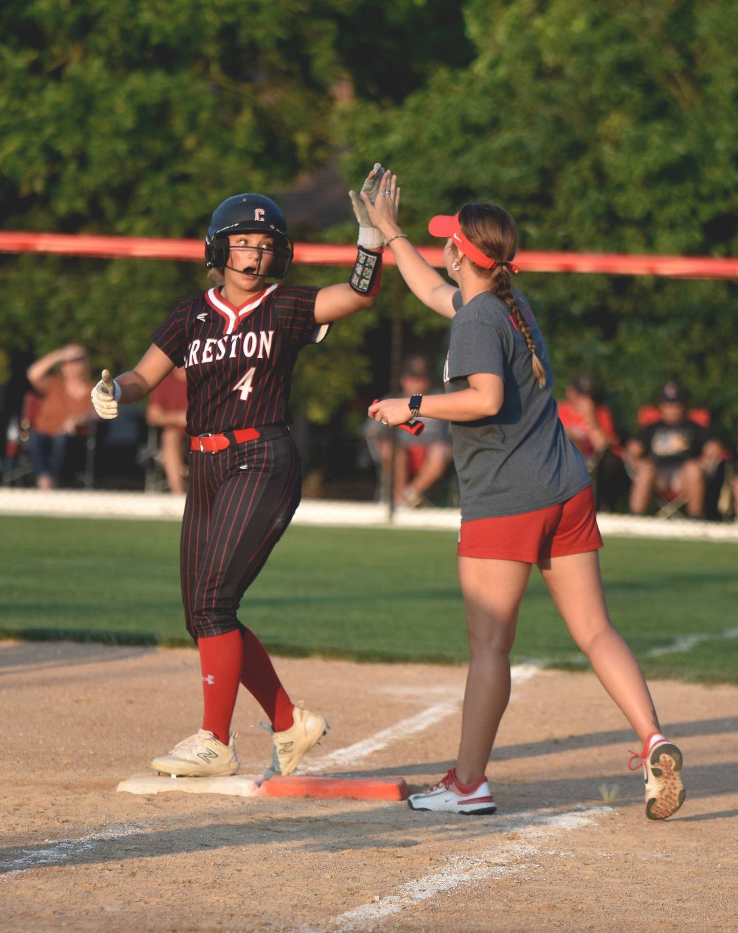 Jersey Foote high fives assistant coach Gracie Hagle after winning a battle at the plate.