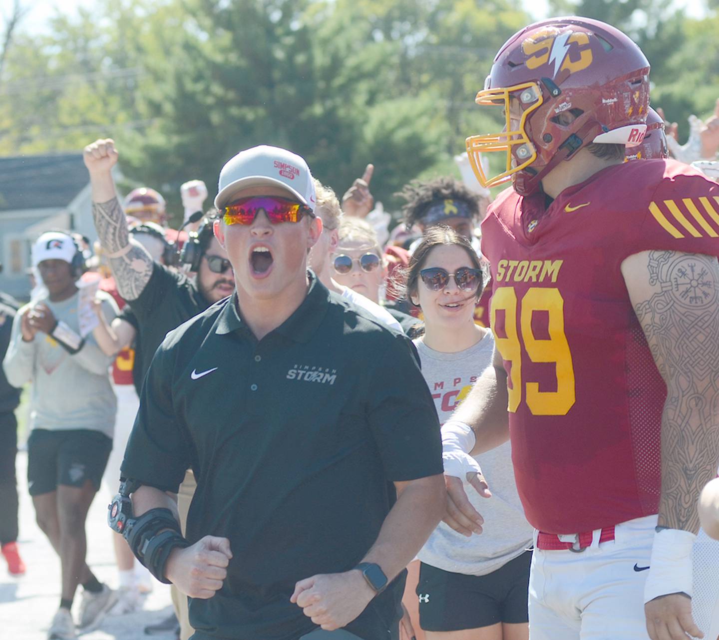 Simpson student coach Briley Hayes cheers for a Simpson touchdown during a conference win over Loras College.