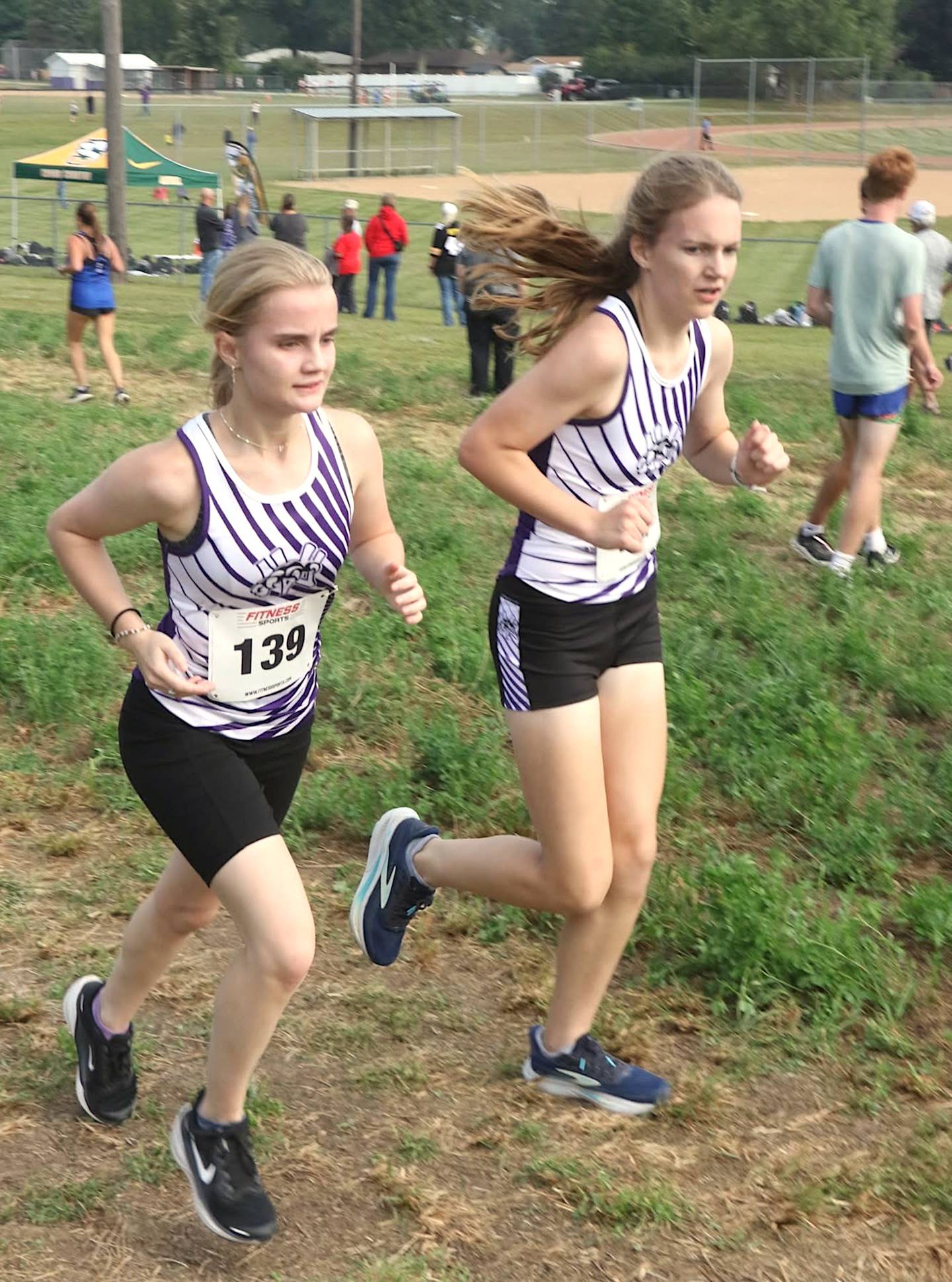 Kaylee Van Horn and teammate Kenzie Lilly run together as the Wolverines opened their cross country season in Redfield.