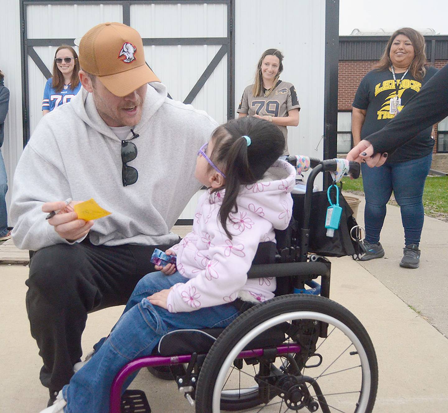 Spencer Brown signs his autograph and chats with a young Lenox student during his visit Friday.
