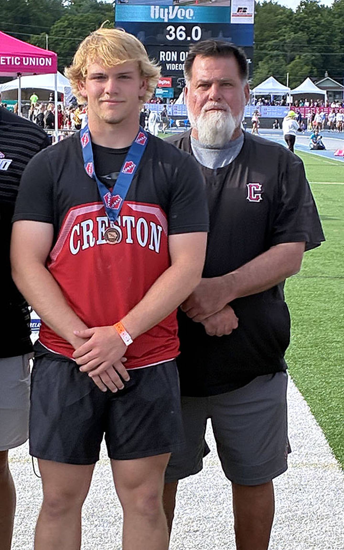Tom Mikkelsen of Creston earned his second seventh-place medal in the Class 3A shot put at a distance of 54-05.50. He is shown with Creston throwing coach Brian Morrison.