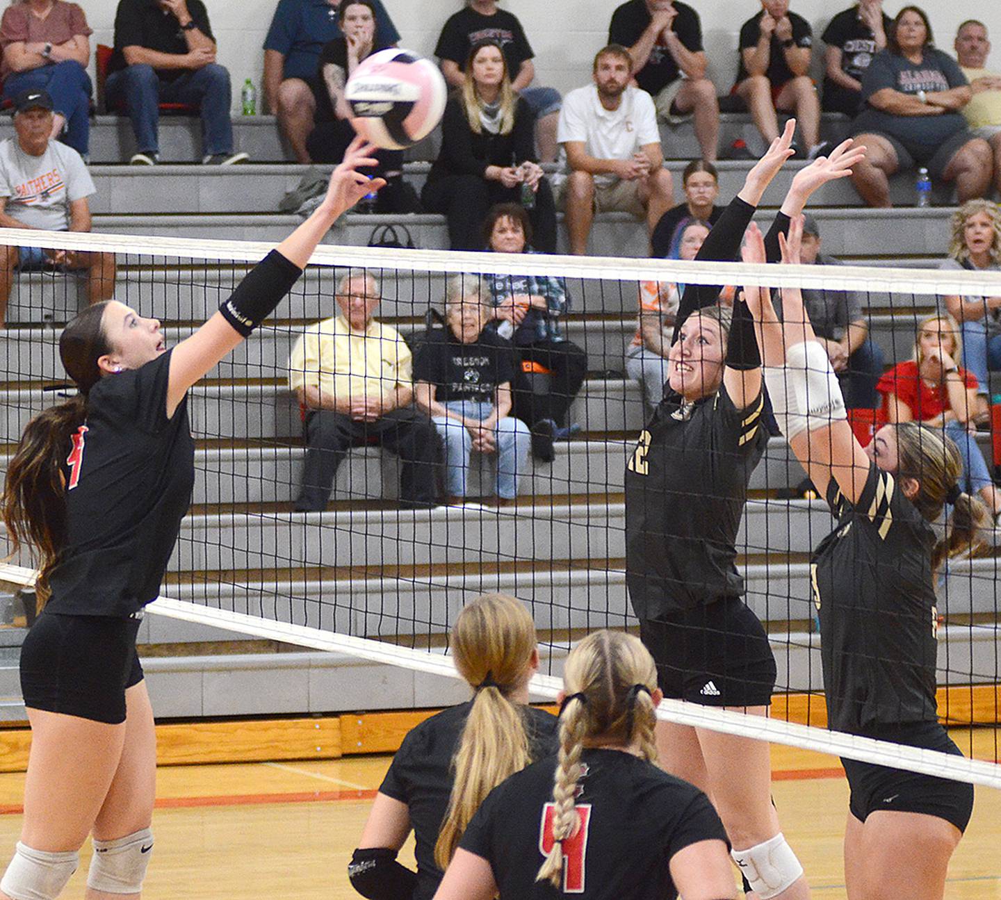 Creston's Hope Henderson tips the ball past two Glenwood blockers. Henderson had nine kills in the loss.