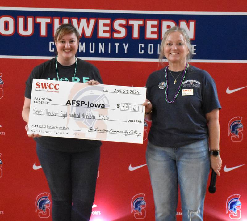 SWCC Director of Marketing and Enrollment Management Terri Higgins hands a check to American Foundation for Suicide Prevention Iowa Area Director Amara Huffine for $7,819.64, the total raised for suicide awareness and prevention through SWCC's Out of Darkness walk.