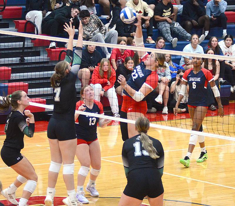 Danyelle Steinkuehler of Southwestern (22) sends an attack against Central blocker Kerry Ryan (7).