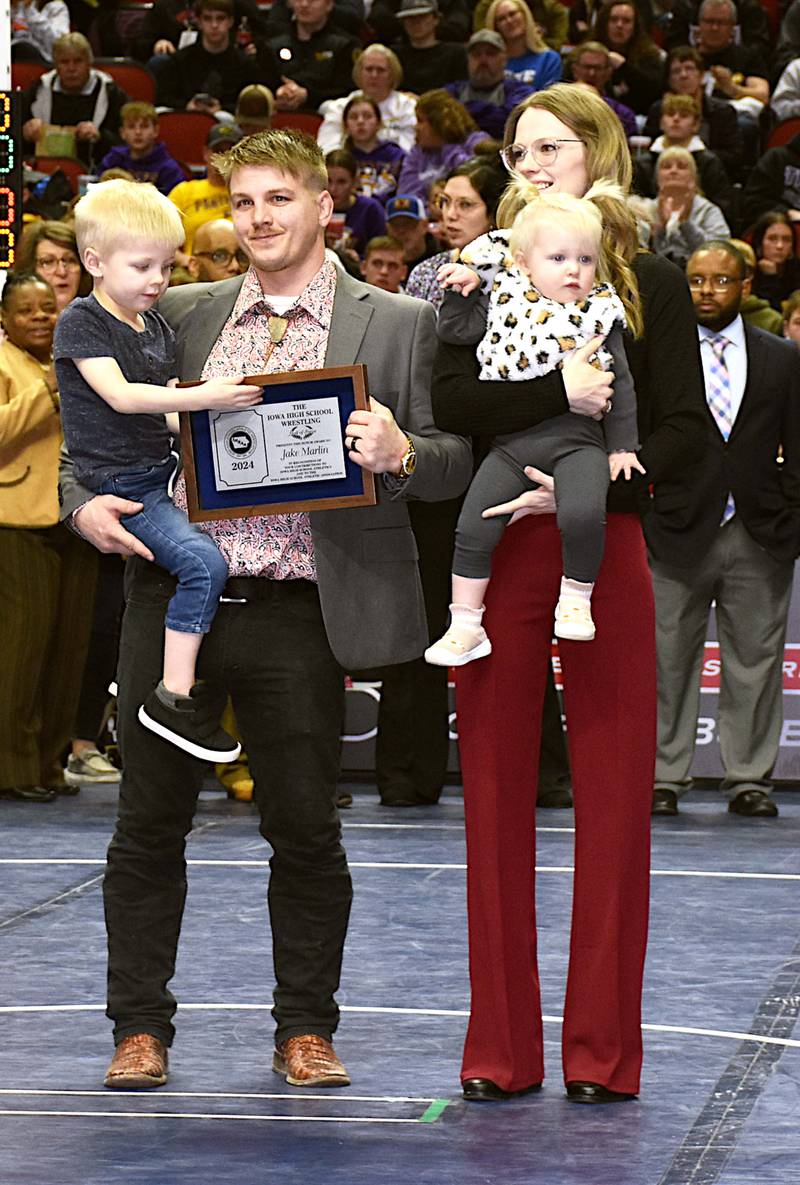 Jake Marlin, a four-time state champion from Creston, displays his IHSAA Wrestling Hall of Fame plaque before the state wrestling finals Feb. 17. Marlin is with his wife Molly, son McCoy and daughter Blake.