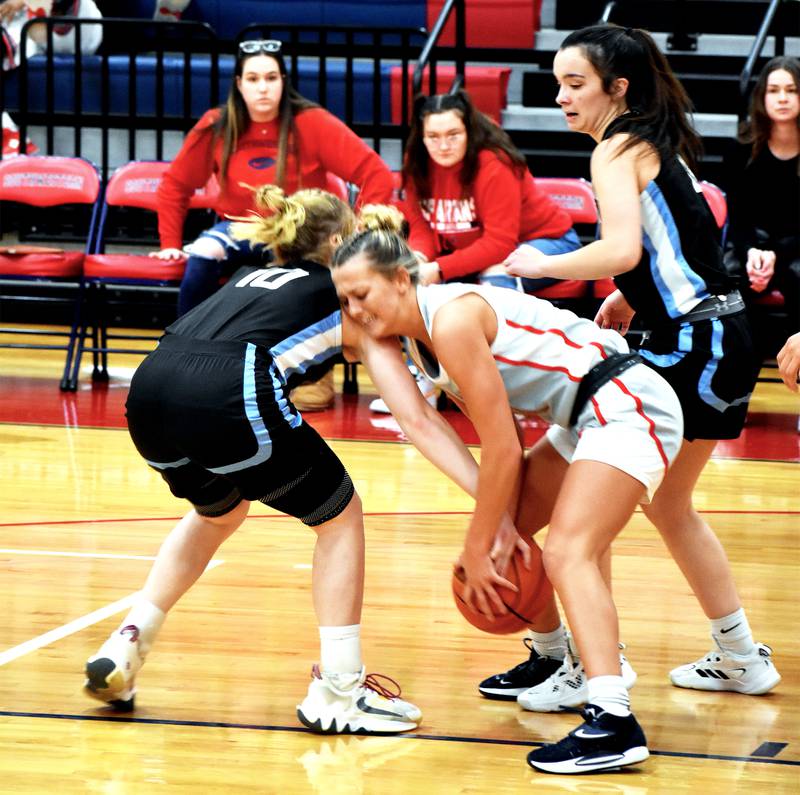 The Spartans' Cassidy Nelson, center, fights for the ball with Jaedyn Ratzlaff of Nebraska's Southeast Community College Monday in their home opener. Nelson had 13 points and five rebounds in their 69-52 loss.