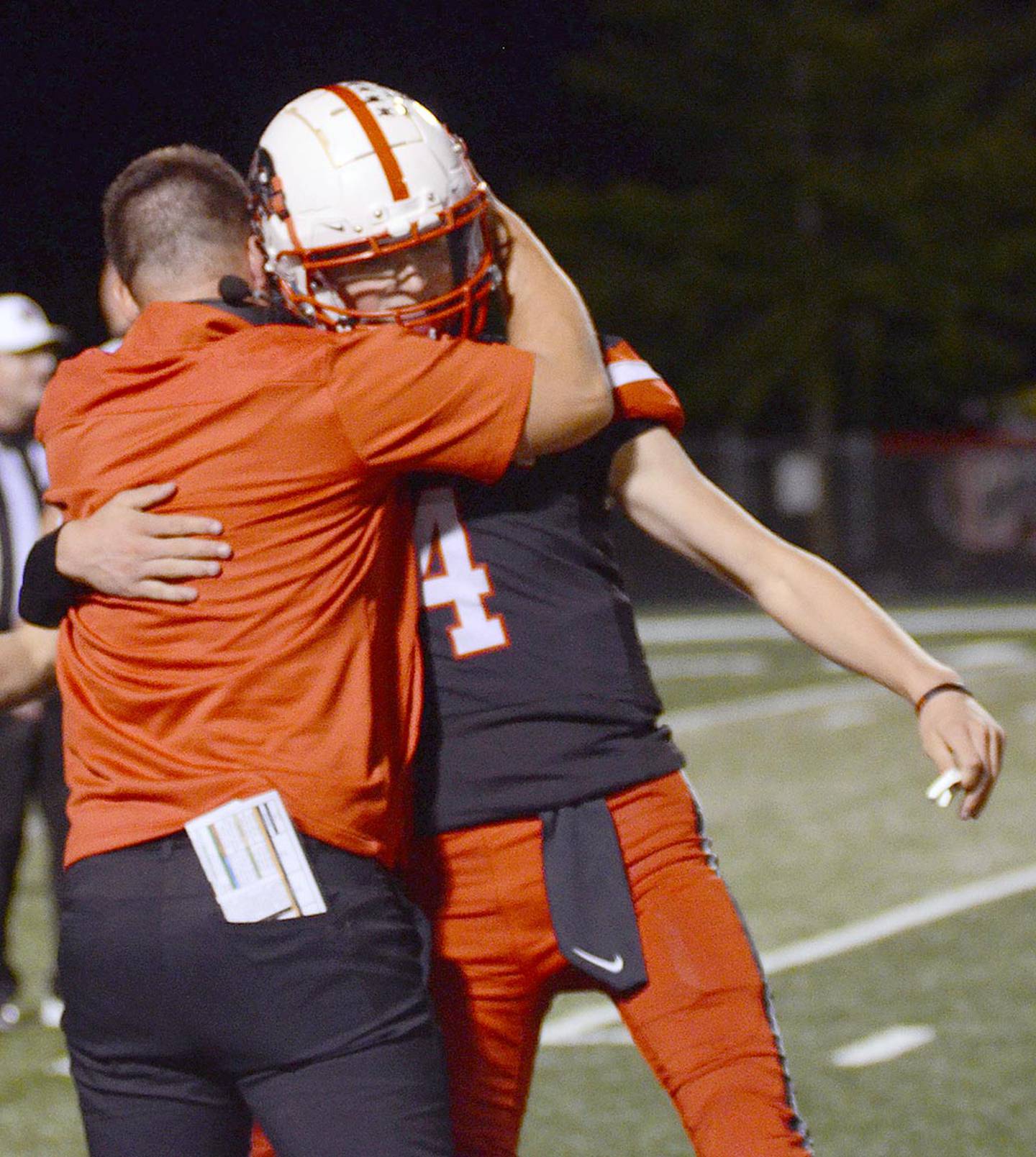 Creston offensive coordinator Garrison Carter hugs quarterback Cael Turner after Friday's 25-22 win over Harlan. Turner leads Class 3A in passing at 75-116 for 1,328 yards with 15 touchdowns and no interceptions.