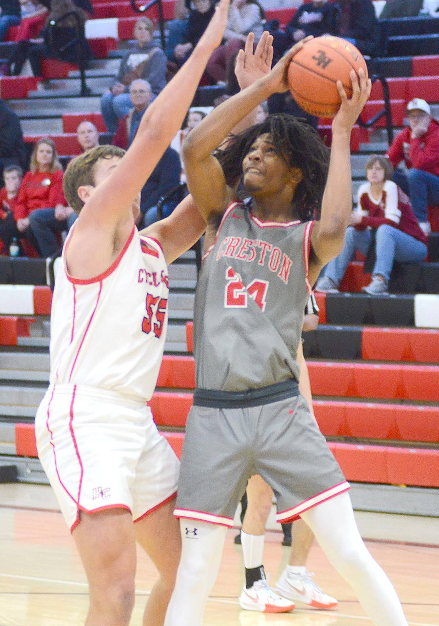 In a battle of two of the top centers in the Hawkeye Ten Conference, Creston's Tony Davidson (24) works for an inside shot against Harlan's Franz Reisz. Davidson finished with nine points.