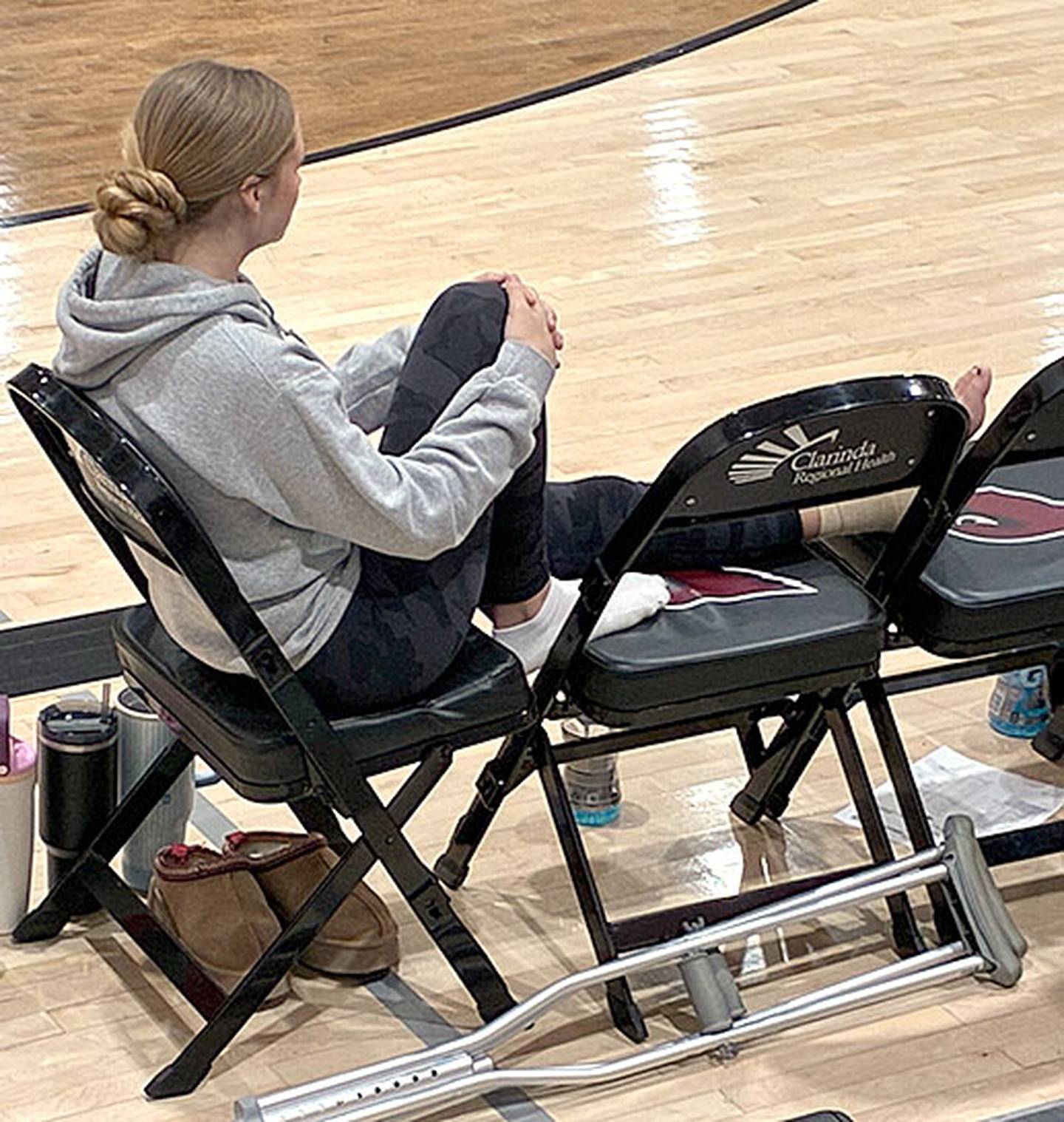 With her crutches nearby, Creston senior Kadley Bailey watches Tuesday's game in Clarinda from the bench. Bailey leads the Panthers with a 21.4 scoring average, which ranks second in Class 3A.