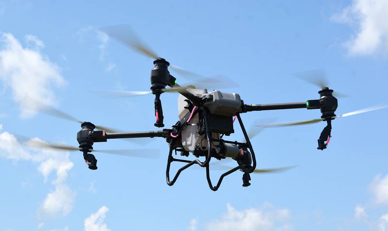The DJI T50 takes off and heads to a nearby plot of land during AgPro's demonstration of the drone on Friday. The drone is powered by a tank of gasoline and a rechargeable battery which is swapped after each use.