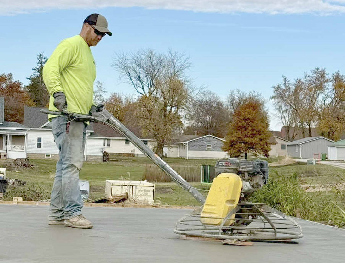 Paulus smooths concrete while working on a neighbor's project.
