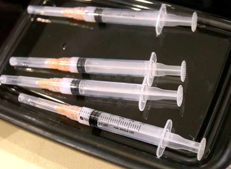 Syringes filled with the Moderna COVID-19 vaccine wait to be used Wednesday at the vaccination site in DeKalb.