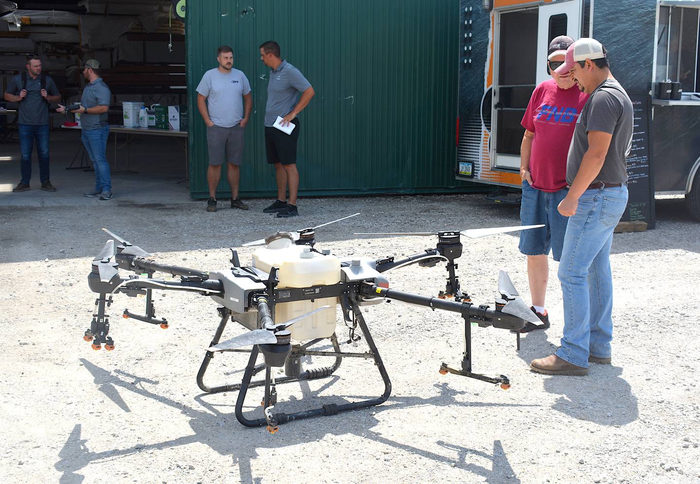 Famers observe the DJI T30 on display. Both drones were available for discussion during Friday's demonstration.