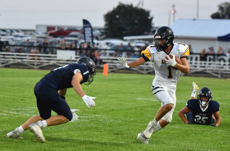 Lenox's Dawson Evans prepares to dodge a tackle Friday in a 41-30 loss against Bedford in the Tigers' first regular-season loss since 2020.