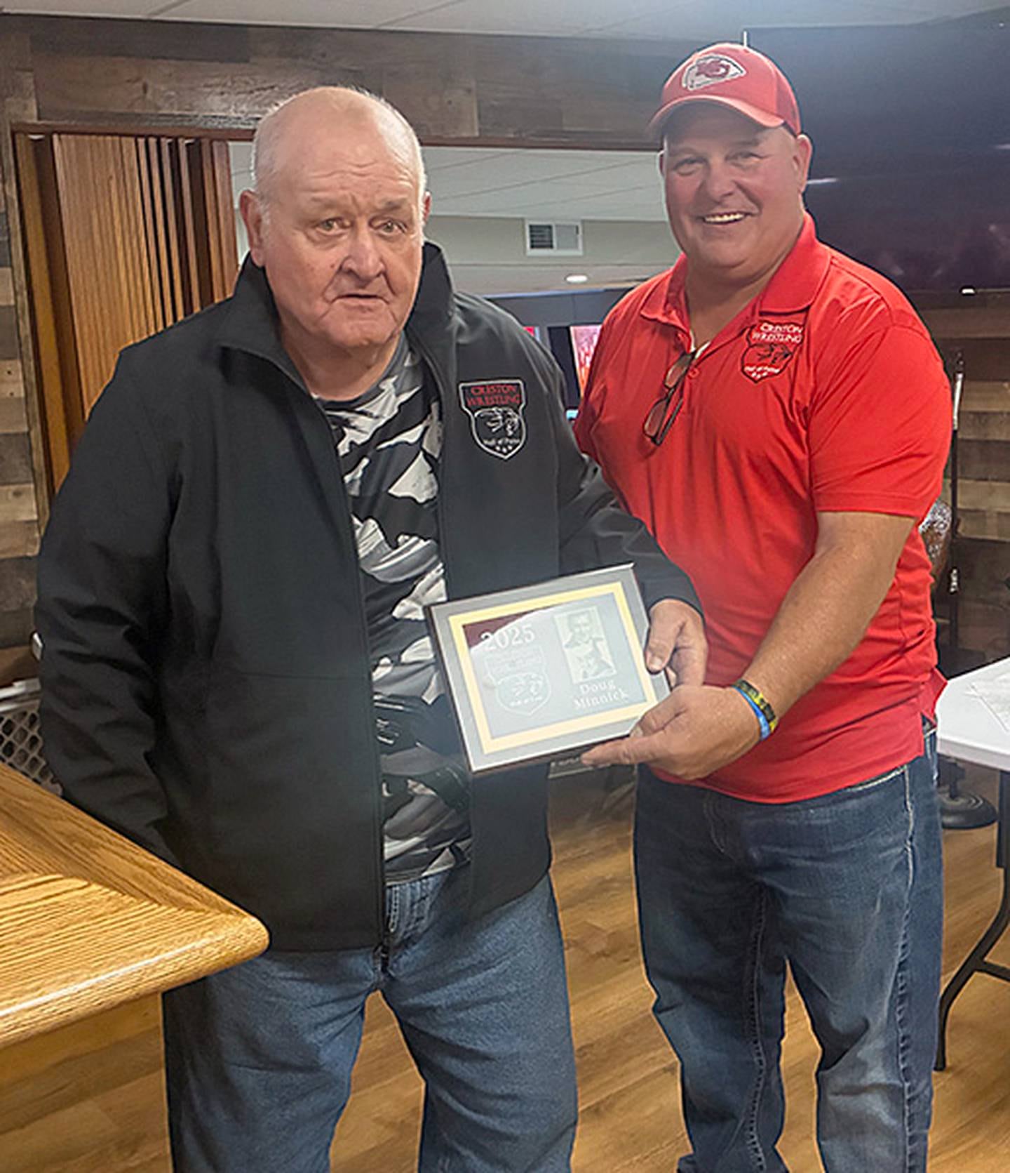 Chuck Hulett of the Creston Wrestling Hall of Fame committee presents the 2025 Hall of Fame plaque to Doug Minnick, 1963 Creston graduate.