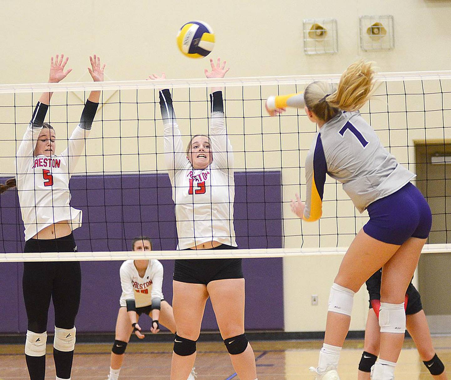Denison-Schleswig senior Addison Inman attacks the block attempt of Creston's Braylee Pokorny (5) and Jaycee Hanson (13). Inman led the Monarchs with 10 kills.