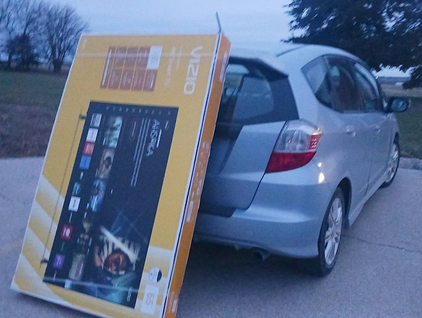 A photo I took on my phone after I managed to bring this giant TV home, compared to the vehicle that, somehow, brought it there.