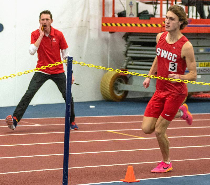 SWCC track and field coach Scott Vicker shouts encouragement to distance runner Chase Oates during the Region XI meet at Buena Vista University. Oates was a national qualifier in the 1,000 meters, placing 18th in a school record time of 2:31.68.