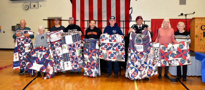 Area veterans display their quilts of valor gifted to them at the Creston High School Veterans Day program Friday morning. The quilts were made by Margaret Kneedler in thanks of their service. Veterans are, from left: Harold Holliday (Army), Sandy Oswald (Army), Garrett Sherley (Army), Rodney Deal (Marine Corps), Patrick Roche (Marine Corps), Jerry Nurnberg (Navy), Cody Miller and Terri Hannah and Hellen Mosman accepting on behalf of Don Mosman (Air Force). Veterans not pictured who received quilts are Nicholas Perry and Alan Johannes.