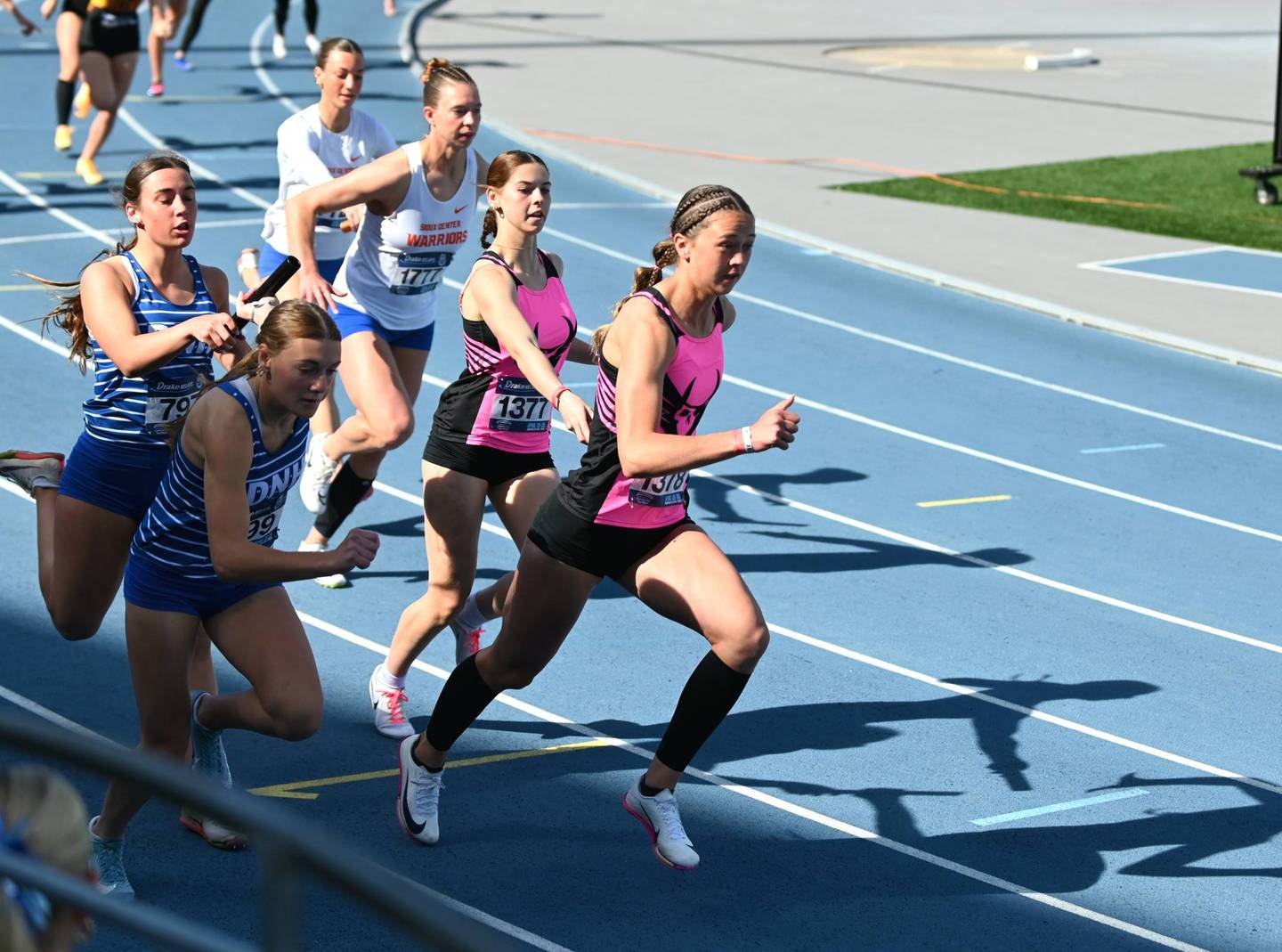 Aubree Shields takes a handoff from leadoff runner Chloe Robb Saturday in the 4x100m relay.